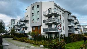 wysoki biały budynek z balkonami w obiekcie Apartament Morski Lazurowy Gdynia w mieście Gdynia