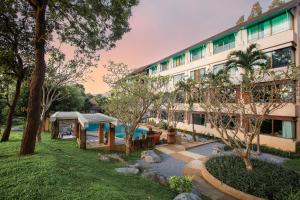 a hotel with a swimming pool and a building at ปานเทล เขาใหญ่ Parntel KhaoYai in Khao Yai