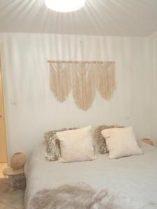 een slaapkamer met een bed met witte lakens en kussens bij Havre de paix Les pélicans in Vichy