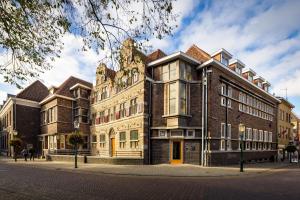 un gran edificio de ladrillo en una calle de la ciudad en Stadsherberg Ald Weishoès - Hostel, en Venlo