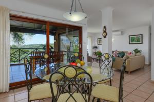 a dining room and living room with a glass table and chairs at San Lameer Villa 1930 - 4 Bedroom Superior - 8 pax - San Lameer Rental Agency in Southbroom