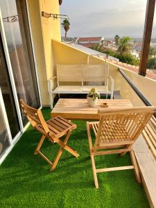 a table and chairs on a balcony with green grass at HAWAII in Eilat