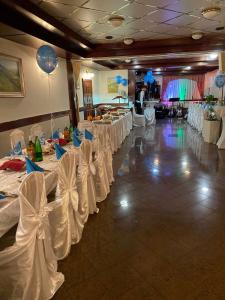 a banquet hall with white tables and white chairs at Rooms Balkovec in Dragatuš