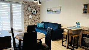 salon z niebieską kanapą i stołem w obiekcie Apartament Morski Lazurowy Gdynia w mieście Gdynia