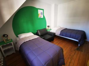 a bedroom with two beds and a green wall at Cinerama Hostel in San Carlos de Bariloche