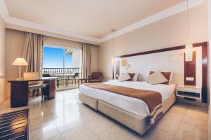 a hotel room with a large bed and a desk at Iberostar Selection Royal El Mansour in Mahdia