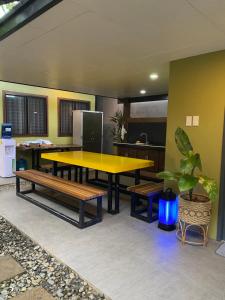 una mesa amarilla y bancos en una habitación en Happy Camper Hostel en Corón