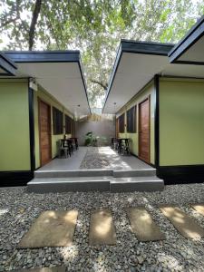 a courtyard of a building with tables and chairs at Happy Camper Hostel in Coron