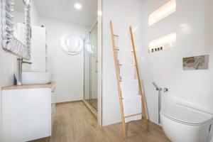 a bathroom with a ladder next to a toilet and a sink at Apartmán pod Vežou 1 in Banská Bystrica