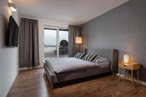 Un dormitorio con una cama y una ventana grande. en Apartmán pod Vežou 1, en Banská Bystrica