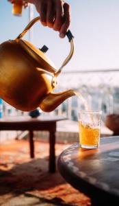 una persona che versa un drink in un bicchiere di The Riad Hostel Tangier a Tangeri