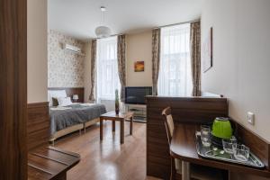 Elit Boutique Rooms- Best Location by BQA في بودابست: غرفة معيشة مع سرير وطاولة طعام