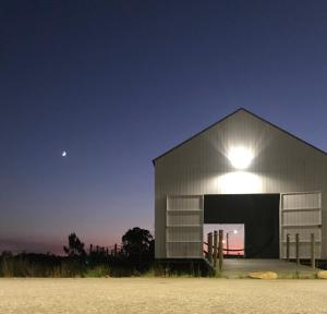 a barn at night with the moon in the sky at Tijosa Eco-House Camp in Ovar