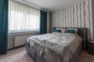 a bedroom with a large bed with blue curtains at Schöne lichtdurchflutete Ferienwohnung mit Balkon in Hagen