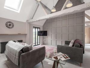 a living room with two couches and a tv at dairy cottages in Wimborne Minster