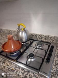 a tea kettle sitting on top of a stove at residance a 100 m de la mer in Ouled Khellouf
