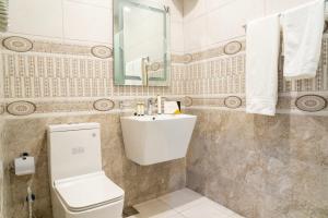 bagno con servizi igienici bianchi e lavandino di فندق ركاز الماسي - Rekaz Diamond Hotel a Sīdī Ḩamzah