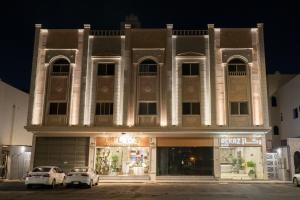فندق ركاز الماسي - Rekaz Diamond Hotel في Sīdī Ḩamzah: مبنى امامه سيارتين