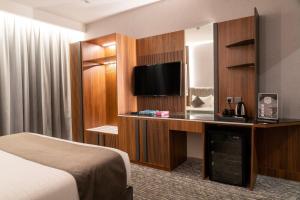 een hotelkamer met een bed en een flatscreen-tv bij فندق ركاز الماسي - Rekaz Diamond Hotel in Sīdī Ḩamzah