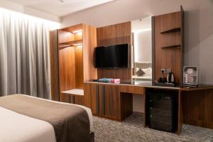 a hotel room with a bed and a flat screen tv at فندق ركاز الماسي - Rekaz Diamond Hotel in Sīdī Ḩamzah