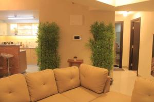 a living room with a couch and green plants at A2J Luxury 3BR Suite Near Uptown Mall BGC Taguig in Manila