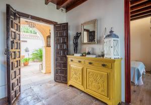 a room with a yellow dresser and an open door at La Tartana Hotel Boutique in La Herradura