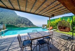 a patio with a table and chairs and a pool at 2 Bedroom Private Villa with great sea view in Faralya