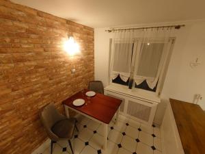 Un comedor con una mesa y una pared de ladrillos. en Gdynia Apartment, en Gdynia 17 fotos más