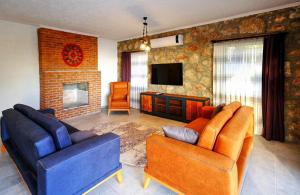 a living room with two couches and a tv at 2 Bedroom Private Villa with great sea view in Faralya
