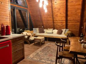 un soggiorno con divano in una camera in legno di Panurla Wooden House havuz & sauna kırmızı a Urla