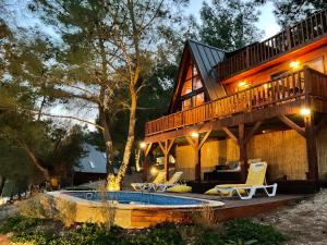 una grande casa con terrazza e piscina di Panurla Wooden House havuz & sauna kırmızı a Urla