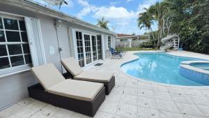 a patio with two chairs and a swimming pool at Pool House on the Water 2 in Miami