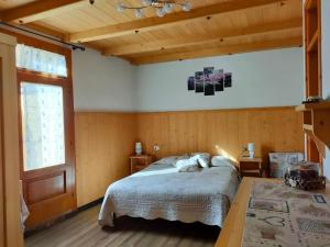 a bedroom with a bed and a large window at Camere vecchio borgo in Bormio
