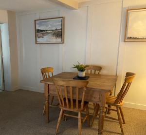 a dining room with a wooden table and chairs at Grade II Listed 2 Bed Cottage with Free Parking in King's Lynn