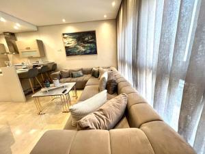 a living room with a large couch and a table at Nice 11 - Spacious & Luxury flat in the heart in Casablanca