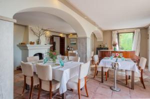 a dining room with white tables and chairs and a fireplace at La Tartana Hotel Boutique in La Herradura