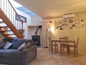 een woonkamer met een bank en een tafel en stoelen bij Gîte "La Cachette"- Mirmande - in Mirmande