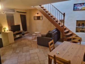 - un salon avec un canapé et un escalier dans l'établissement Gîte "La Cachette"- Mirmande -, à Mirmande