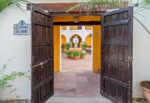 an open door into a courtyard with plants at La Tartana Hotel Boutique in La Herradura
