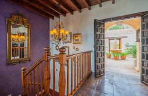 a hallway with a staircase and a mirror at La Tartana Hotel Boutique in La Herradura