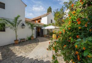 a courtyard of a house with an orange tree at La Tartana Hotel Boutique in La Herradura