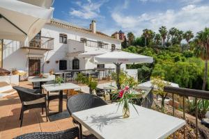 a patio with tables and chairs and a building at La Tartana Hotel Boutique in La Herradura
