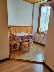 una sala da pranzo con tavolo, sedie e finestra di Camere vecchio borgo a Bormio