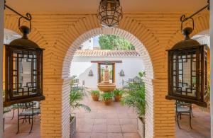 an archway in a patio with chairs and a fountain at La Tartana Hotel Boutique in La Herradura