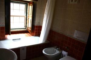 a bathroom with a toilet, sink and tub at Hotel Convento Nossa Senhora do Carmo in Freixinho