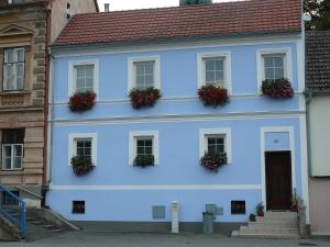 uma casa azul com vasos de flores ao lado em Apartman Modry dum em Vranov nad Dyjí