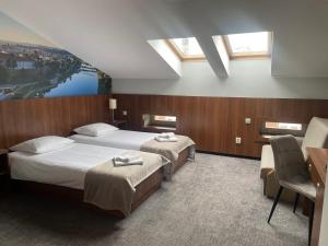 a hotel room with two beds and a desk at Hotel Downtown Kraków in Kraków