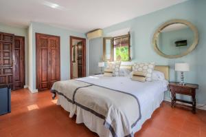 a bedroom with a large white bed and a mirror at La Tartana Hotel Boutique in La Herradura