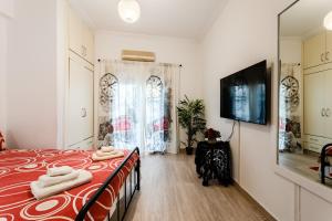 - une chambre avec un lit et une télévision murale dans l'établissement Mets, à Athènes