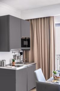 a kitchen with a sink and a table with chairs at Plaza Regency Hotels in Sliema